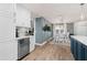 Open-concept dining area with wood floors, wainscotting, and a view of the cabinetry and countertops in the kitchen at 611 Limetree Dr, Oldsmar, FL 34677