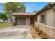 Single-story home with stone accents, driveway, lawn, landscaping, garage and covered entryway at 611 Limetree Dr, Oldsmar, FL 34677