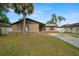 Charming single-story home with stucco exterior, stone accents, driveway, lawn and mature landscaping at 611 Limetree Dr, Oldsmar, FL 34677