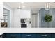 A modern kitchen features an island with a quartz countertop, a beverage cooler, and stylish pendant lighting at 611 Limetree Dr, Oldsmar, FL 34677