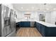 Modern kitchen with stainless appliances, sleek white cabinets, and contrasting navy blue island at 611 Limetree Dr, Oldsmar, FL 34677