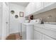 Efficient laundry room with white cabinetry, modern washer/dryer, and stylish wallpaper at 611 Limetree Dr, Oldsmar, FL 34677