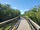 Scenic view of elevated wooded trail with wooden railing on a beautiful day at 611 Limetree Dr, Oldsmar, FL 34677