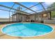 Screened-in pool with patio furniture, jacuzzi and TV at 611 Limetree Dr, Oldsmar, FL 34677