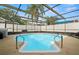 Inviting screened-in pool with spa, surrounded by lush landscaping for privacy at 611 Limetree Dr, Oldsmar, FL 34677