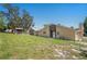 View of the backyard featuring a brick house and large grassy area at 7169 Spruce Dr, Weeki Wachee, FL 34607