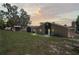 View of the backyard featuring a brick house and large grassy area at 7169 Spruce Dr, Weeki Wachee, FL 34607