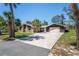View of the front exterior featuring the driveway and palm trees at 7169 Spruce Dr, Weeki Wachee, FL 34607