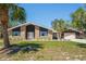 Charming single-story brick home featuring an expansive lawn and a detached two-car garage at 7169 Spruce Dr, Weeki Wachee, FL 34607
