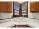 Close-up of a kitchen sink with wooden cabinets and a view from the window at 7169 Spruce Dr, Weeki Wachee, FL 34607