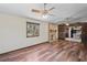 Inviting living room featuring wood-look floors, a ceiling fan, and a brick fireplace at 7169 Spruce Dr, Weeki Wachee, FL 34607