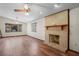 Warm living room with brick fireplace, hardwood floors, and natural light from windows at 7169 Spruce Dr, Weeki Wachee, FL 34607