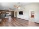 Inviting living room featuring wood-look floors, ceiling fan, and an opening to the kitchen at 7169 Spruce Dr, Weeki Wachee, FL 34607