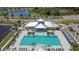 Aerial view of the community pool, clubhouse and lounge area with palm trees and ample seating at 7215 Wash Island Dr, Sun City Center, FL 33573