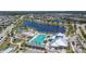 Aerial view showcasing the community's pool, playground, and surrounding residential area with lakes at 7215 Wash Island Dr, Sun City Center, FL 33573