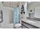 Bright bathroom with granite vanity top, decorative accents, and combination tub and shower at 7215 Wash Island Dr, Sun City Center, FL 33573