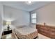 Bedroom with a queen bed, dresser, bedside table, and a bright, natural light source at 7215 Wash Island Dr, Sun City Center, FL 33573
