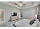 A carpeted main bedroom features tray ceilings, fan, TV, and an ensuite bathroom at 7215 Wash Island Dr, Sun City Center, FL 33573