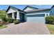 Charming home with blue siding, manicured landscaping and paver driveway leading to a two-car garage at 7215 Wash Island Dr, Sun City Center, FL 33573