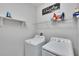 Bright laundry room featuring a washer, dryer and wire shelving at 7215 Wash Island Dr, Sun City Center, FL 33573