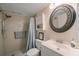 A full bathroom with tiled shower and vanity with round mirror at 7700 92Nd St # 207, Seminole, FL 33777