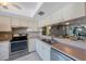 This modern kitchen has an oven, a stainless steel sink, white cabinetry, and tile backsplash at 7700 92Nd St # 207, Seminole, FL 33777