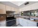 This modern kitchen has an oven, a stainless steel sink, white cabinetry, and tile backsplash at 7700 92Nd St # 207, Seminole, FL 33777