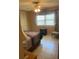 A cozy bedroom featuring neutral tones, a ceiling fan, and natural light from a window at 7701 Starkey Rd # 602, Seminole, FL 33777