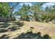 The grassy backyard is enclosed by wood fencing and shaded by mature trees, ideal for Gathering gatherings at 9208 N 27Th St, Tampa, FL 33612