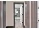 View into the bathroom with toilet and tiled shower/tub through an open door and dark trim at 9208 N 27Th St, Tampa, FL 33612