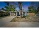 Charming single story home with a light green exterior, front car port, and tidy landscaping at 9208 N 27Th St, Tampa, FL 33612
