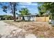 A quaint one-story home with a car port, fresh light green paint and tidy yard surrounded by trees at 9208 N 27Th St, Tampa, FL 33612