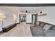 Bright living room featuring modern flooring, gray sectional couch, and access to the kitchen at 9208 N 27Th St, Tampa, FL 33612