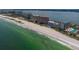 Aerial shot shows beachfront condos lining the coast with sparkling ocean, offering serene coastal living at 1350 Gulf Blvd # 301, Clearwater Beach, FL 33767
