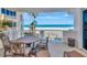 A waterfront balcony with a beach and ocean view is furnished with a table and four chairs at 1350 Gulf Blvd # 301, Clearwater Beach, FL 33767