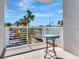 Balcony with views of tropical palm trees and a blue table with a metal base at 1350 Gulf Blvd # 301, Clearwater Beach, FL 33767
