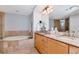 Bright bathroom features double sinks with granite counters, tile floor, and a large soaking tub at 1350 Gulf Blvd # 301, Clearwater Beach, FL 33767