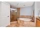 Luxurious bathroom with a soaking tub and a glass-enclosed shower with neutral color stone tiles at 1350 Gulf Blvd # 301, Clearwater Beach, FL 33767