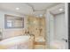 Inviting bathroom with soaking tub and separate tiled shower featuring neutral tile colors and hardware at 1350 Gulf Blvd # 301, Clearwater Beach, FL 33767