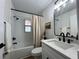 Modern bathroom featuring a shower-tub combo, black fixtures, and a white vanity with stone countertop at 10408 N 50Th St # 1/2, Tampa, FL 33617