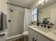 Modern bathroom featuring a shower-tub combo, black fixtures, and a white vanity with stone countertop at 10408 N 50Th St # 1/2, Tampa, FL 33617