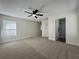 Bright, carpeted bedroom with a ceiling fan, closet, and an ensuite bathroom featuring a tiled walk-in shower at 10408 N 50Th St # 1/2, Tampa, FL 33617