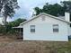 An exterior view of a home with a wooden porch, a well maintained lawn and mature trees at 10408 N 50Th St # 1/2, Tampa, FL 33617