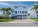 This two-story home boasts a charming blue facade, multiple balconies, and a spacious three-car garage at 11105 5Th E St, Treasure Island, FL 33706