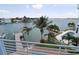 Beautiful waterfront view from a balcony, featuring palm trees, a private dock, and a swimming pool at 11105 5Th E St, Treasure Island, FL 33706