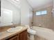 Bathroom with single sink vanity, toilet, bathtub and shower with tile surround at 11414 Weston Course Loop, Riverview, FL 33579