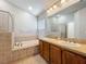 Bathroom featuring double sinks, a large mirror, a soaking tub and shower at 11414 Weston Course Loop, Riverview, FL 33579