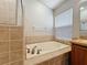 Bright bathroom with a soaking tub, tile surround, and a separate glass-enclosed shower at 11414 Weston Course Loop, Riverview, FL 33579