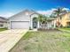 Charming single-Gathering home featuring a two-car garage and well-maintained lawn with mature palm trees at 11414 Weston Course Loop, Riverview, FL 33579