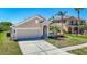 Lovely single-Gathering home featuring a two-car garage, arched entryway, and lush landscaping at 11414 Weston Course Loop, Riverview, FL 33579